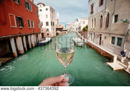 Drinking Wine Over Venice Embankments. Bar Visitor With Glass Of Prosseco Walking Past Old Houses Of