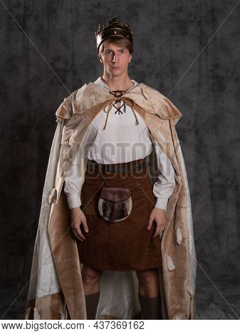 The Young King. A Noble Young Man In A Fantasy Historical Costume, In A Fur Robe And With A Crown On