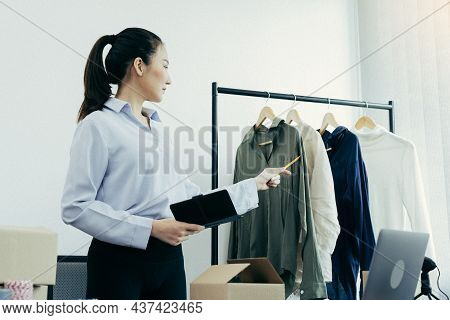 Young Asian Entrepreneurs Check Their Clothes Before Selling Them To Customers.