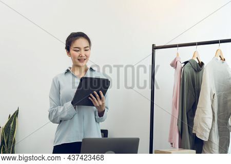 Young Asian Entrepreneurs Use A Tablet While Checking Online Purchase Orders.