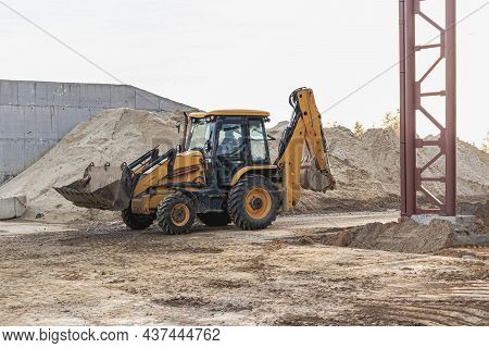 An Excavator In The Front Bucket Removes Soil For Backfill At The Construction Site. Construction Eq