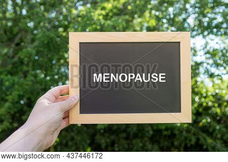 Menopause Word Abstract Text Written On Chalck Board, Green Blurred Background