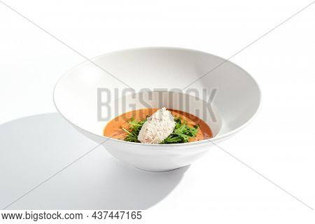 Summer Spanish soup gazpacho with crab meat and rucola isolated on white background. Delicious cold tomato soup with crab. Clean eating for diet.Healthy food in restaurant menu. Crab gazpacho