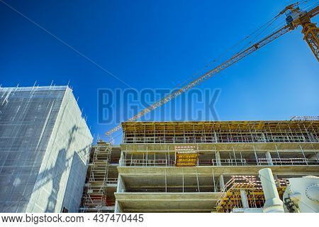 New Construction Site With Building Cranes Against Blue Sky.