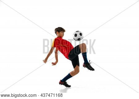 Portrait Of Boy, Teenager, Professional Football Player In Motion, Kincking A Ball With Knee Isolate