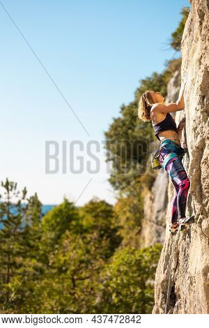 The Girl Climbs The Rock. The Climber Trains On Natural Terrain.  A Woman Overcomes A Difficult Clim