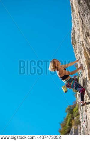 The Girl Climbs The Rock. The Climber Trains On Natural Terrain.  A Woman Overcomes A Difficult Clim