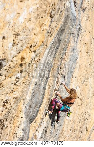 The Girl Climbs The Rock. The Climber Trains On Natural Terrain. Extreme Sport. Outdoor Activities. 