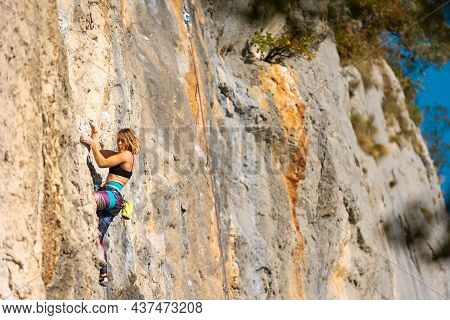 The Girl Climbs The Rock. The Climber Trains On Natural Terrain. Extreme Sport. Outdoor Activities. 
