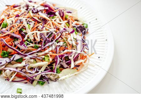 Coleslaw Cabbage Salad With Cabbage, Carrots, Herbs And Sesame Seeds On A White Plate. Healthy Eatin