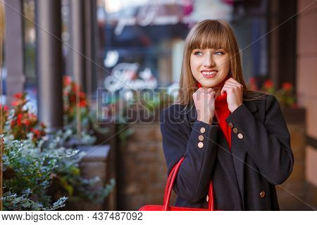 Street Photo Portrait Walking Girl Close Up. Cheerful Attractive Young Woman With Red Handbag And We