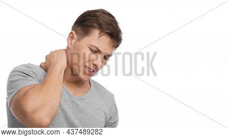 Despaired Attractive Millennial European Muscular Male Suffer From Neck Pain, Presses Hand To Sore S