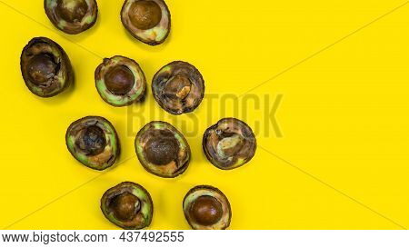 Rotten Avocado Halves On Yellow Background. Food Fruits Cannot Be Eaten. Overripe Avocado Fruit Cuts