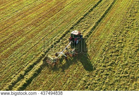 Tractor Raking Grass For Silage Harvesting. Agriculture Machinery Working At Field. Grass Silage For