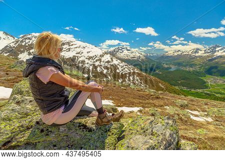 Woman Resting On Top Of Muottas Muragl Mountain In Switzerland. Popular Location For Mountain Excurs