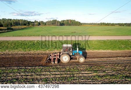 Tractor On Cultivating Field Work. Soil Tillage In Farmers Country. Agricultural Tractor On Cultivat