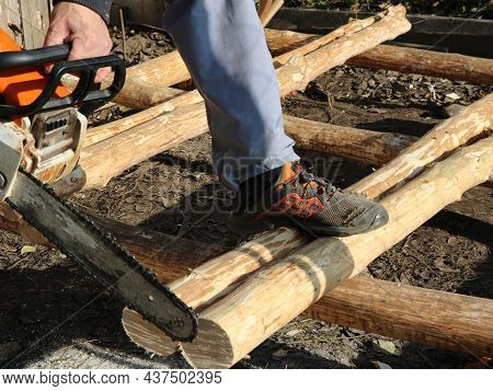 Sawing Off Part Of The Logs With A Chainsaw Close-up, Working In A Village With Building Materials U