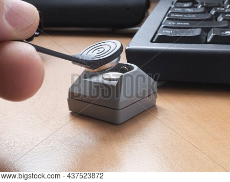 A Man's Hand Puts A Touch Memory Key On The Reader To Access The Computer. The Concept Of Cybersecur