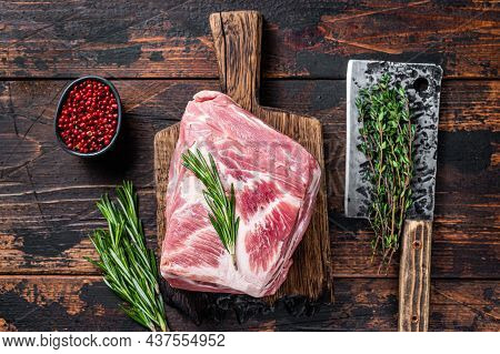 Pork Shoulder Raw Meat For Fresh Steaks On Wooden Cutting Board With Butcher Cleaver. Dark Wooden Ba