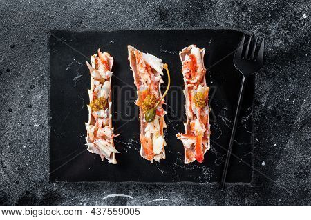 Crab Leg Meat In A Sheel With Herbs. Black Background. Top View