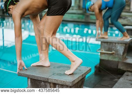 Some Athletes Stand On The Blockboard In A Position To Jump And Swim