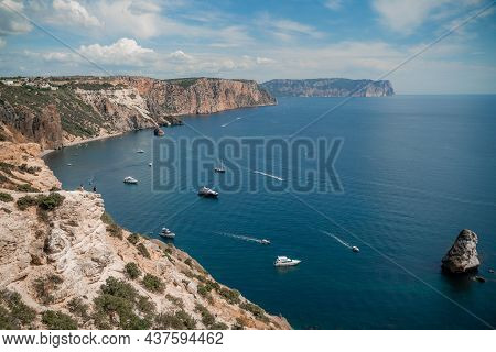 Two Rocks Stick Out Of The Water In The Middle Of The Turquoise Sea. Scenic Ocean View. Speed Boat S