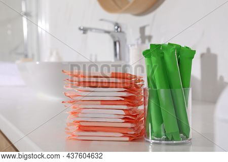 Tampons And Menstrual Pads On Counter In Bathroom. Feminine Hygiene Products