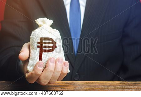A Businessman Holds In His Hand A Philippine Peso Money Bag. Nvestments, Financing. Stimulating Econ