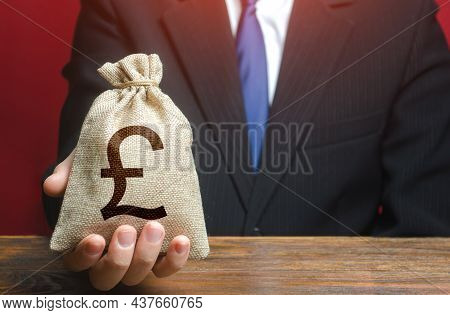 Man Gives A British Pound Sterling Money Bag. Loan Issuance. Financial Support, Leasing. Investments