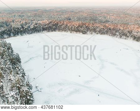 Beautiful Aerial View Of Ice Covered Balzis Lake. Snowy Pine Forests Surrounding A Small Lake. Rime
