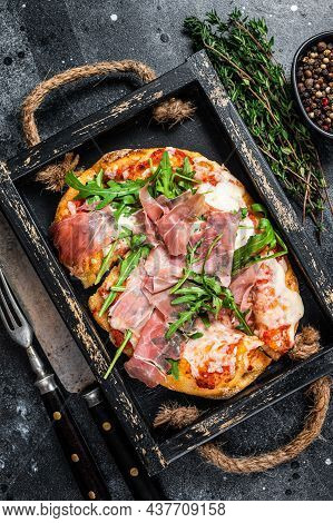 Italian Pizza With Prosciutto Parma Ham, Arugula Salad And Cheese In A Rustic Wooden Tray. Black Bac