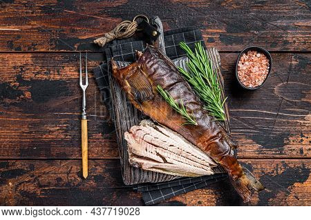 Cut Hot Smoked Fish On A Wooden Board With Rosemary. Dark Wooden Background. Top View
