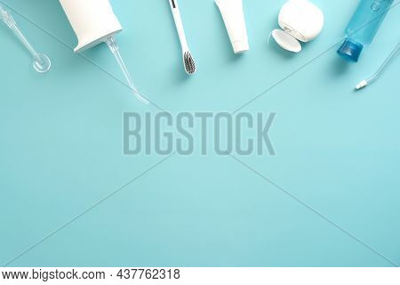 Dental Professional Oral Irrigator, Toothpaste, Toothbrush, Liquid, Flosser On Blue Background. Flat
