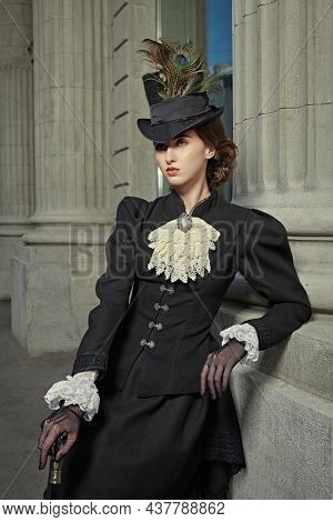 Portrait of an elegant 19th century lady during her walk along a city street. History and Fashion of the late 19th - early 20th century. 