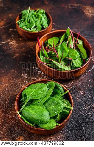 Mix Salad Leafs, Arugula, Spinach And Swiis Chard In Wooden Bowls. Dark Background. Top View