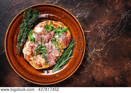 Pizza With Prosciutto Parma Ham, Arugula Salad And Parmesan Cheese In A Rustic Plate. Wooden Backgro