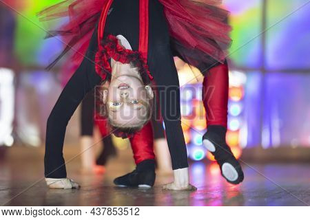 Little Girls Are Performing A Dance Number. Dance For The Hellovinna In Red Costumes. Dancing Little