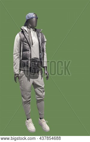 Full Length Image Of A Male Display Mannequin Wearing Warm Padded Jacket Isolated On A Green Backgro
