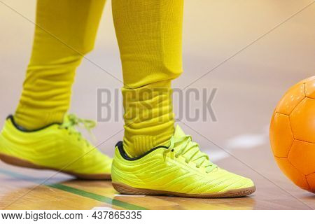 Boy In Soccer Clothes With Ornage Futsal Ball. Kid On Indoor Soccer Training With Coach. Child Playi