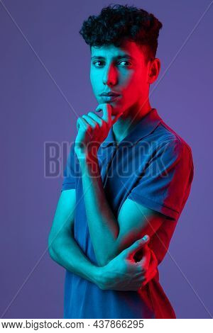 Cropped Portrait Of Young Boy In T-shirt Talking With Thoughtfull Expression Isolated Over Purple Ba