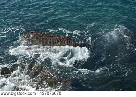 Sea Waves Crashing On The Rocks With White Foam. Swirling Frothy Foamy Sea Water Over The Rock Near 