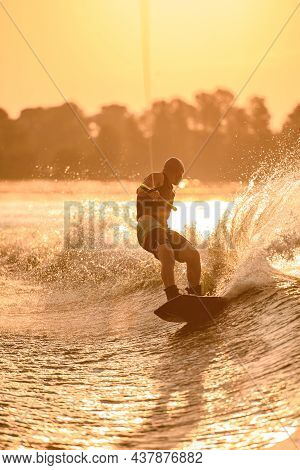 Man Holds Rope And Speedly Riding Wakeboard On The River.