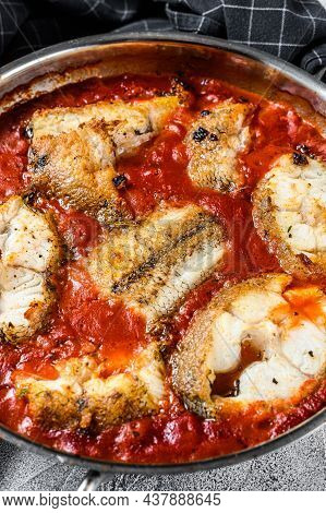 Baked Hake White Fish With Tomato In A Pan. White Wooden Background. Top View