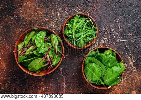 Mix Salad Leafs, Arugula, Spinach And Swiis Chard In Wooden Bowls. Dark Background. Top View