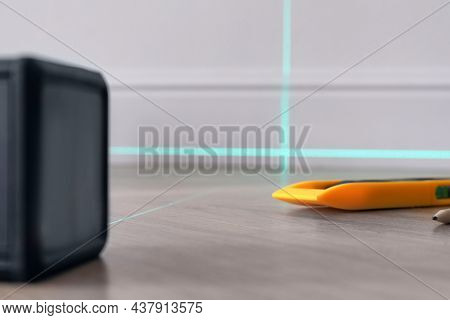 Cross Line Laser Level And Other Tools On Wooden Floor Indoors