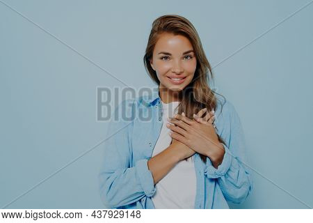 Friendly Looking Beauitiful Female With Long Brown Hair Keeps Hands On Heart, Expresses Her Love To 