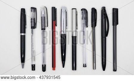 Horizontal Shot Of A Group Of Different Types Of Black Pens Arranged Parallel To Each Other Isolated