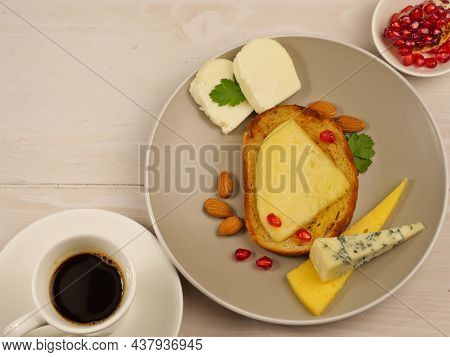 Sandwich With Cheese, Cheese Slicing On A Gray Plate. A Cup Of Coffee, Pomegranate Seeds, Almonds, D