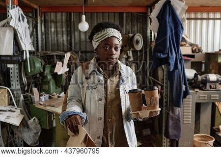 African Woman Carrying Coffee Cups And Packet With Breakfast While Coming To Work In The Morning