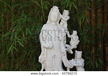 Guanyin met Childran op Bambo Boom In de tuin.